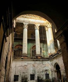 an old building with columns and pillars in the middle of it's interior area