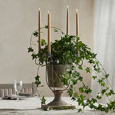 a table with candles and ivy on it