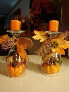 two glass vases filled with pumpkins and burlap ribbon