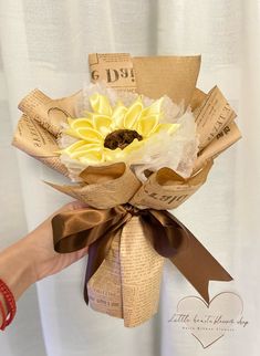 a person holding a bouquet of flowers made out of newspaper