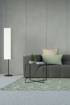 a gray couch sitting next to a lamp on top of a table