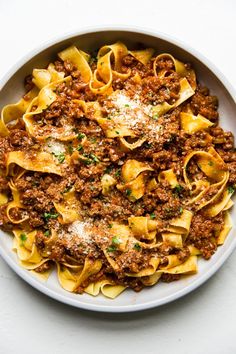 a white bowl filled with pasta and meat sauce