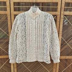 CROSS POSTED and in person at my Vintage Booth.  A prompt refund will be given if item has already been sold.  Thank you for understanding.  Lovely vintage cream lace blouse with high ruffle collar, box pleats and blouson sleeves!  Has a Victorian vibe. Great piece for layering or wearing alone with faded denim.  DETAILS: Good condition 1970s Era Feels like polyester lace Cream/off white shade Ruffle collar Box pleat details down front with hidden buttons Blouson sleeves with button cuff Straight hem  Washed, ready to wear FLAWS: **a hint of gray at edges on cuffs, neck but no one would notice **has a perfume scent, I washed but it is still there LABEL:  None  MEASUREMENTS while flat: Shoulder:  15" Sleeves:  22" Bust:  36" Waist:  33" Hips:  36" Length:  24" MODERN FIT SIZE:  SMALL TO MED Vintage Booth, Faded Denim, 70s Vintage, Vintage Victorian, Ruffle Collar, Denim Details, Cream Lace, Lace Ruffle, Box Pleats