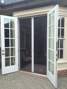 an open patio door to a house with french doors on both sides and side windows