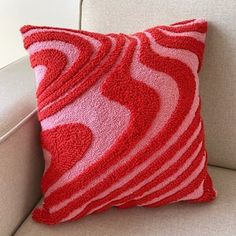 a red and white pillow sitting on top of a couch