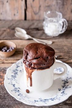 a chocolate muffin sitting on top of a white saucer