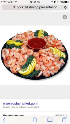 a plate with shrimp, broccoli, lemons and ketchup on it