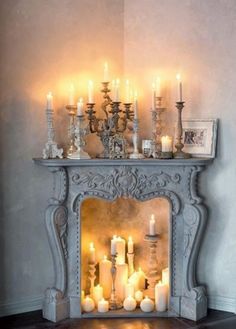 a mantel with candles and pictures on it