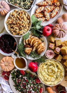 a table topped with lots of plates and bowls filled with different types of food on top of it