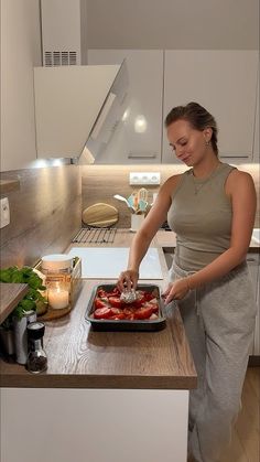 a woman is preparing food in the kitchen