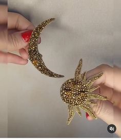 two hands are holding an object that looks like a star and moon