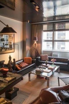 a living room filled with lots of furniture and a large window overlooking the cityscape