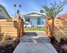 an open gate leading to a house