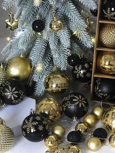 a christmas tree surrounded by gold and black ornaments