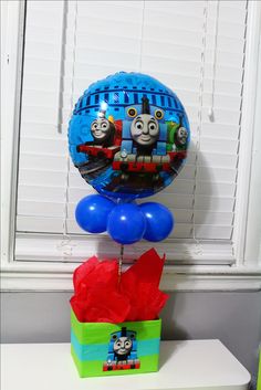 thomas the tank engine balloon sitting on top of a box