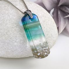 a glass pendant is sitting on a rock