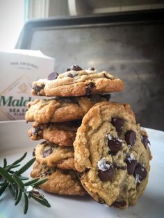 a stack of cookies sitting on top of a white plate next to a box of milk