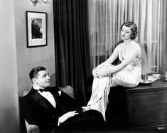 an old black and white photo of a man in a tuxedo sitting next to a woman