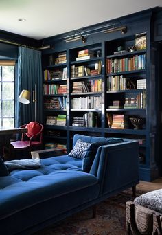 a living room filled with blue furniture and bookshelves