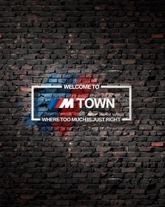 a brick wall with the words welcome to downtown painted on it in white and blue