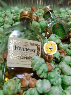 two bottles of hennessy gin sitting on top of some green grapes and nuts