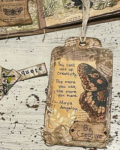 some tags are hanging on a white wooden surface with butterflies and words written on them