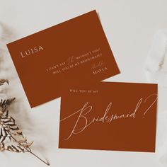 two cards with the word bridesmaid written on them next to some dried flowers