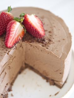 there is a chocolate cake with two strawberries on the top and one slice missing