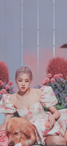 a woman sitting next to a dog on top of a bed of pink and white flowers