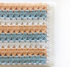 a close up of a piece of crocheted material with blue and white stripes