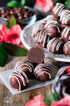 several chocolates on plates with flowers in the background