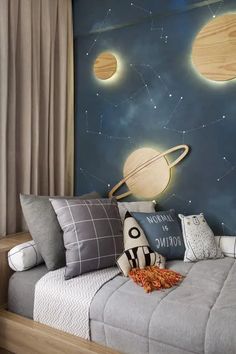 this is a bedroom with a space theme painted on the wall and bed in front of it