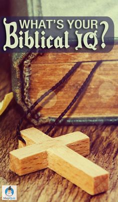 a wooden cross sitting on top of a table next to an open book with the words what's your biblical q?