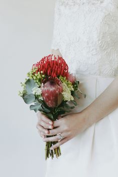 a woman holding a bouquet of flowers in her hands