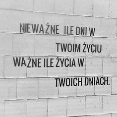 black and white photograph of wall with names written on it's side in different languages