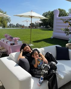 a woman and child sitting on a couch outside