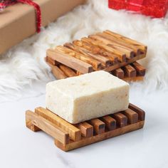 two soap bars sitting on wooden coasters next to a box with a red ribbon