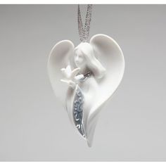 an angel ornament hanging from a chain on a gray background with a white dove