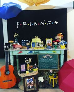 a table topped with an umbrella next to a chalkboard covered in pictures and decorations