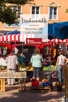 people are shopping at an outdoor market in the town square, with red and white striped awnings