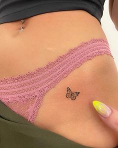 a woman's stomach with a butterfly tattoo on her left side ribcage