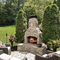 an outdoor fireplace surrounded by wicker chairs