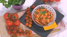 a plate of pasta and tomatoes on a table