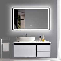 a bathroom with a sink, mirror and towel rack on the wall next to it