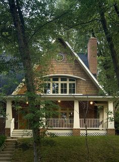 a house in the woods with stairs leading up to it's front door and porch