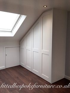 an empty room with white walls and wooden floors