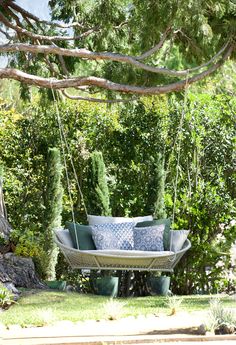 a blue and white swing chair hanging from a tree