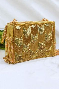 Gold rectangle-shaped box clutch with tone-on-tone sequin, cutdana hand-embroidery enhanced with beaded crystal tassels. Comes with detachable  long metal crossbody chain with faux suede shoulder guard.
Type: Embroidered
Composition: Velvet, Faux Suede
Color: Gold
1 main compartment with small stitched pocket inside
Multi-bead tassels
Closure: Magnetic
 - Aza Fashions Bead Tassels, Shoulder Guard, Gold Handbags, Box Clutch, Gold Velvet, Handbags Online, Beaded Tassels, Online Accessories, Aza Fashion