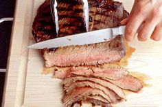 a person cutting meat with a large knife