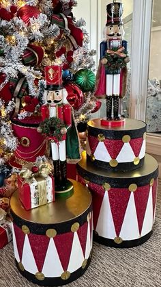 three nutcrackers sitting next to a christmas tree